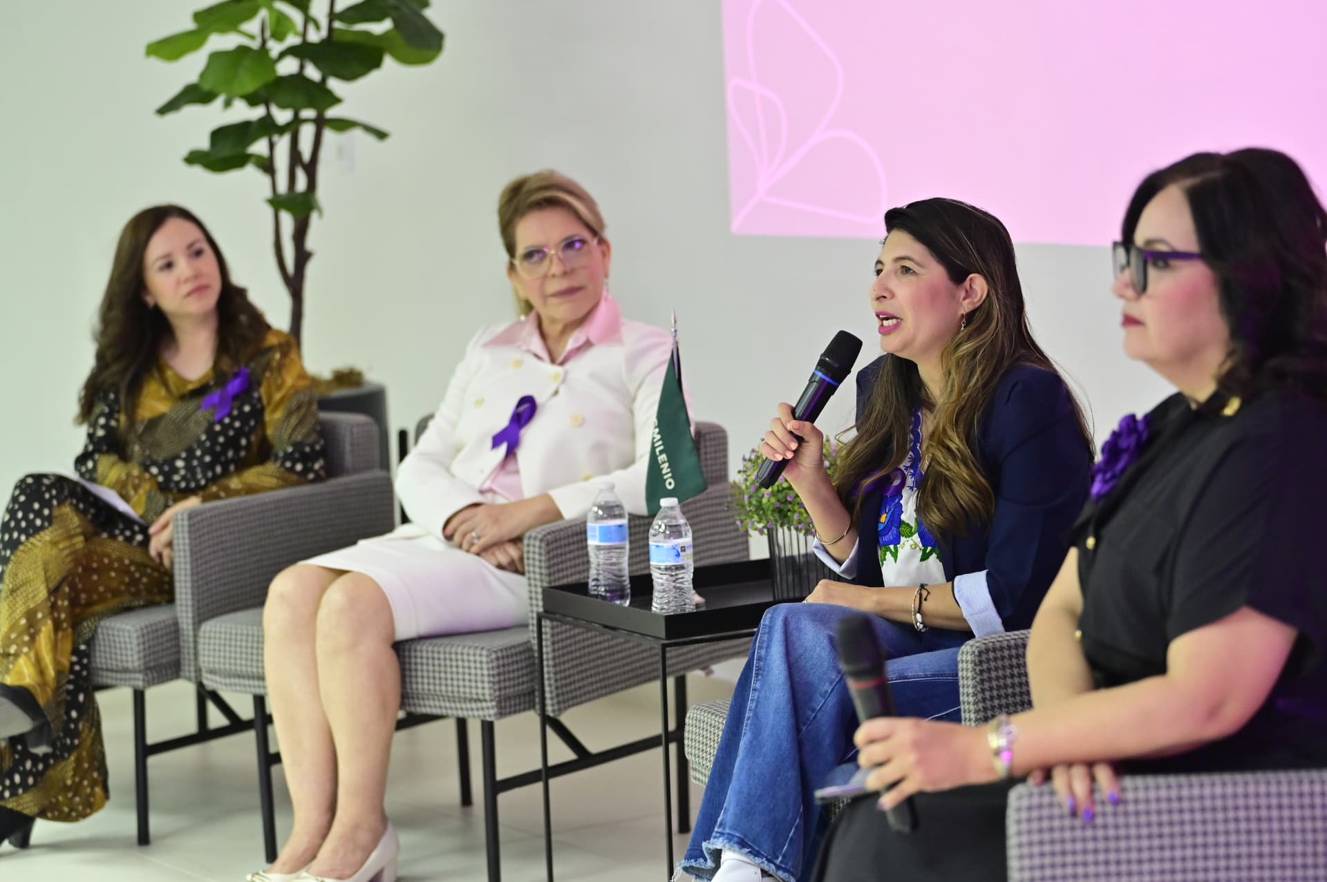 Una de las panelistas toma el micrófono durante el conversatorio por el Día Internacional de la Mujer