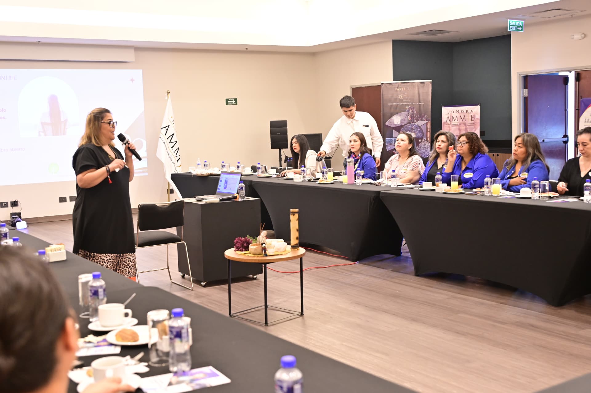 Presentación de una empresaria socia frente al presídium durante el desayuno empresarial de abril de 2026